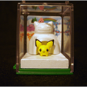 A close-up of the affectionately named "Winterchu".

A little Pichu crouching under a Snorlax snow fort. A little background card goes under the plast
